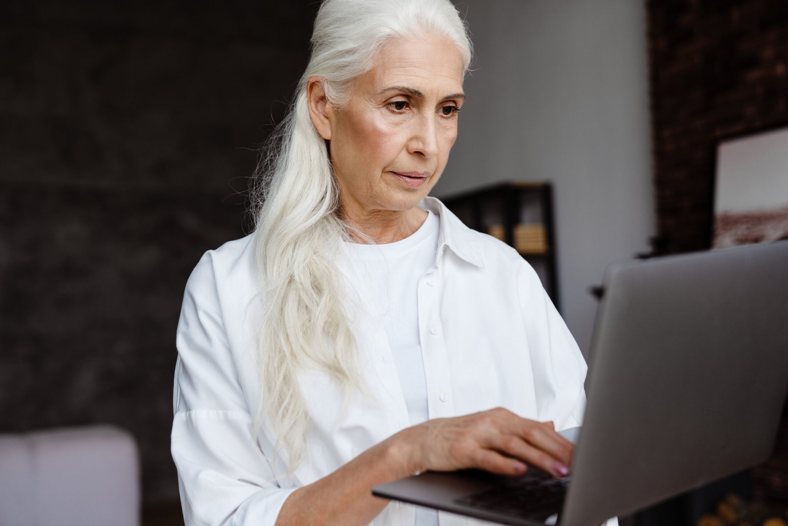 older woman using laptop to build a website easily for a nonprofit organization using 501techstack